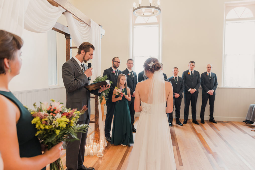 Bride and Groom listening to the officiant during their wedding ceremony in Utah, taken by Robin Kunzler Photo