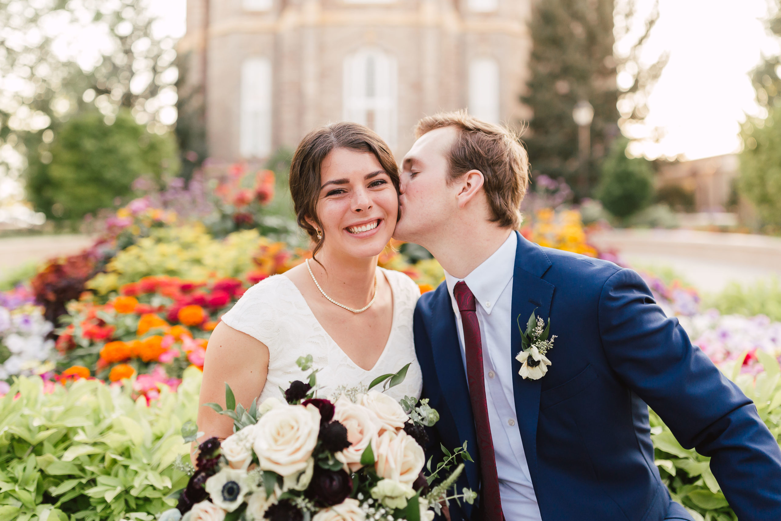 Bride and groom share a kiss in front of Logan Utah Temple, taken by Robin Kunzler Photo