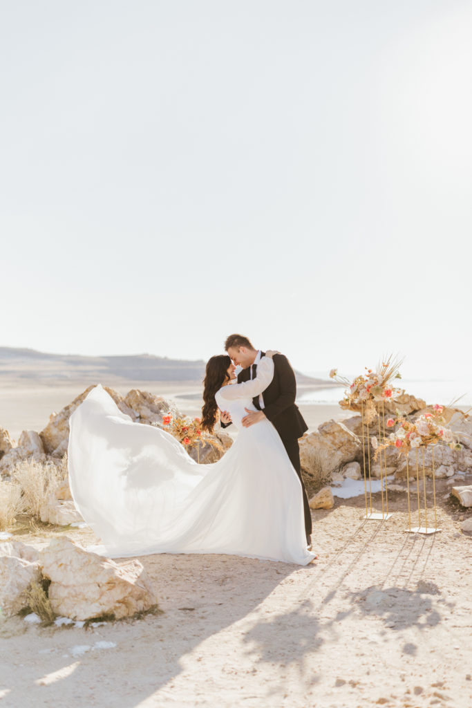 Bride and groom sharing an embrace as they smile at each other at a bright, picturesque location, taken by romantic wedding photographer Robin Kunzler