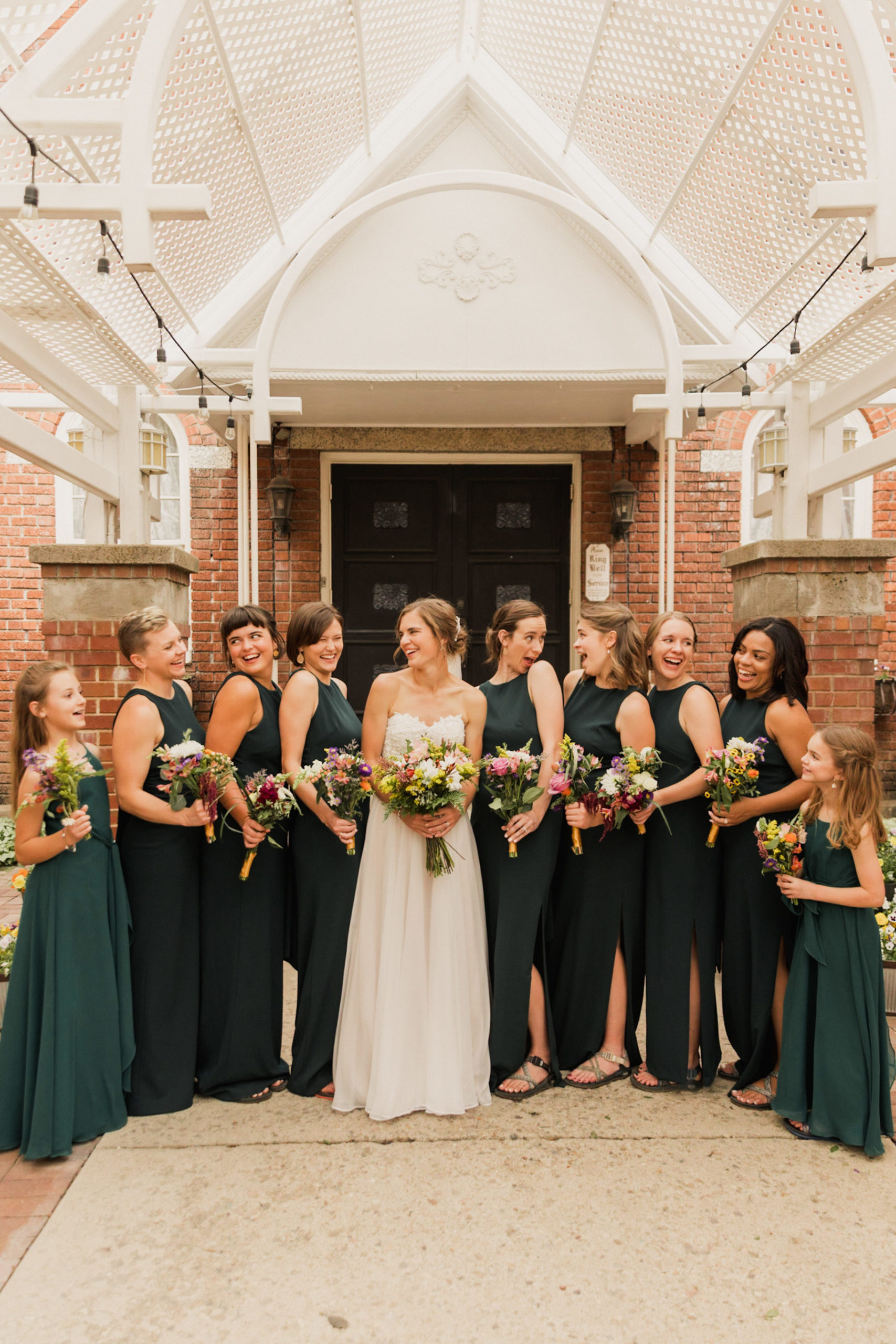 Getting Comfortable In Front of the Camera For Your Wedding Day: Bridesmaids with the bride smile and laugh as they think about how amazing the wedding day has gone so far.