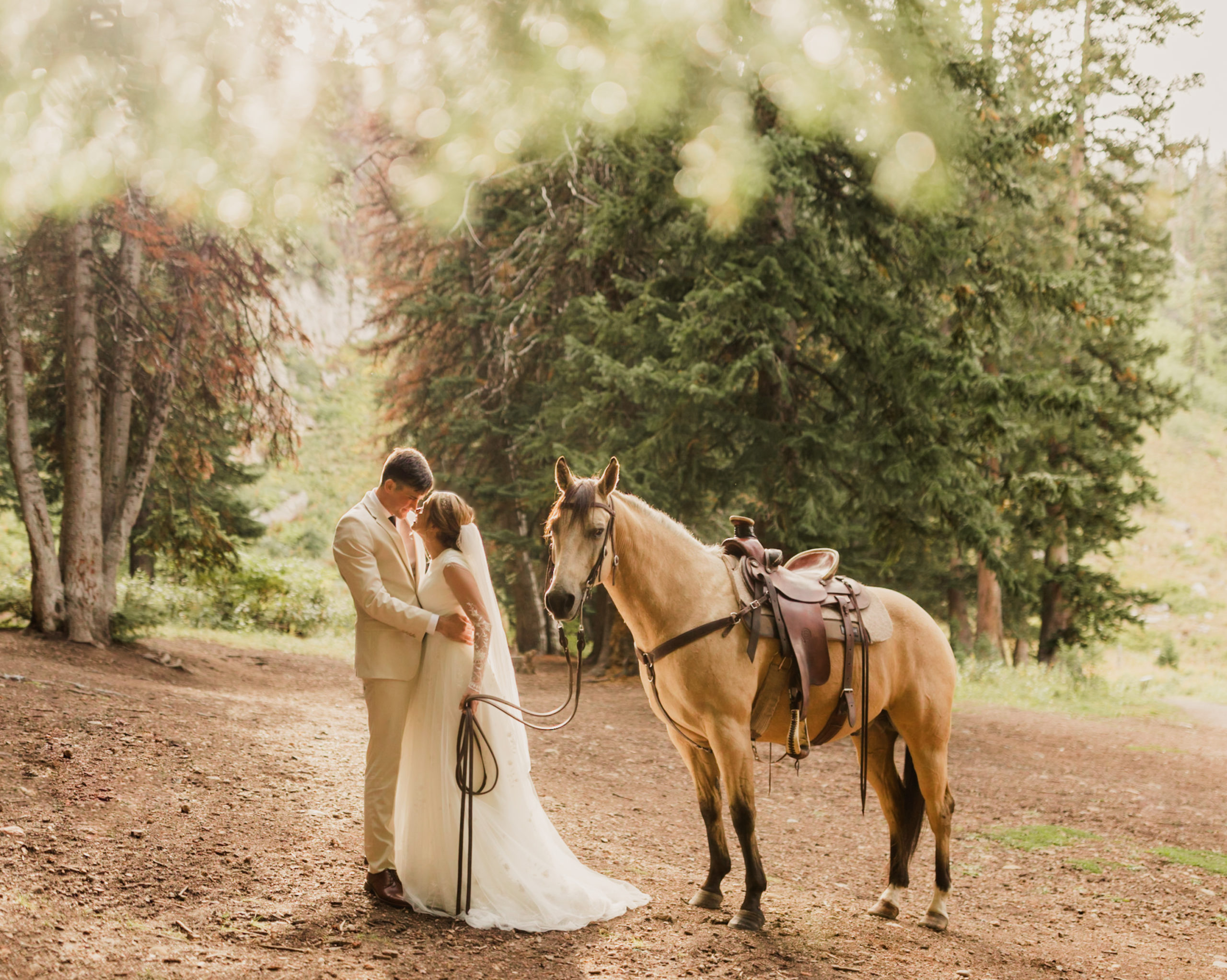 Couple sharing an embrace next to horse, taken by Utah Western Wedding Photographer Robin Kunzler