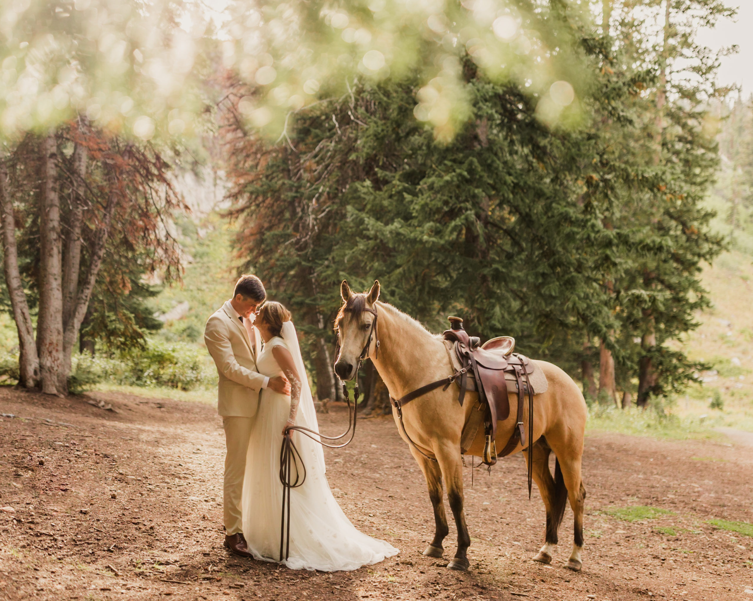 Couple sharing an embrace next to horse, taken by Utah Western Wedding Photographer Robin Kunzler