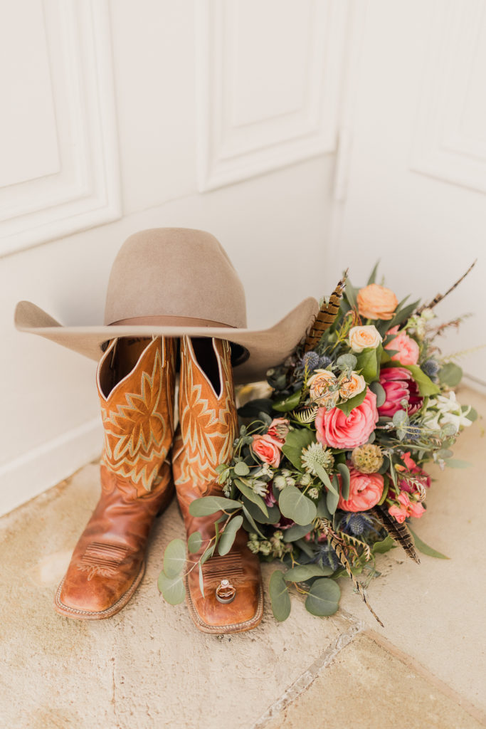 What to look for when hiring a Utah Western Wedding Photographer.  Boots placed beside bouquet and hat on the carpet.