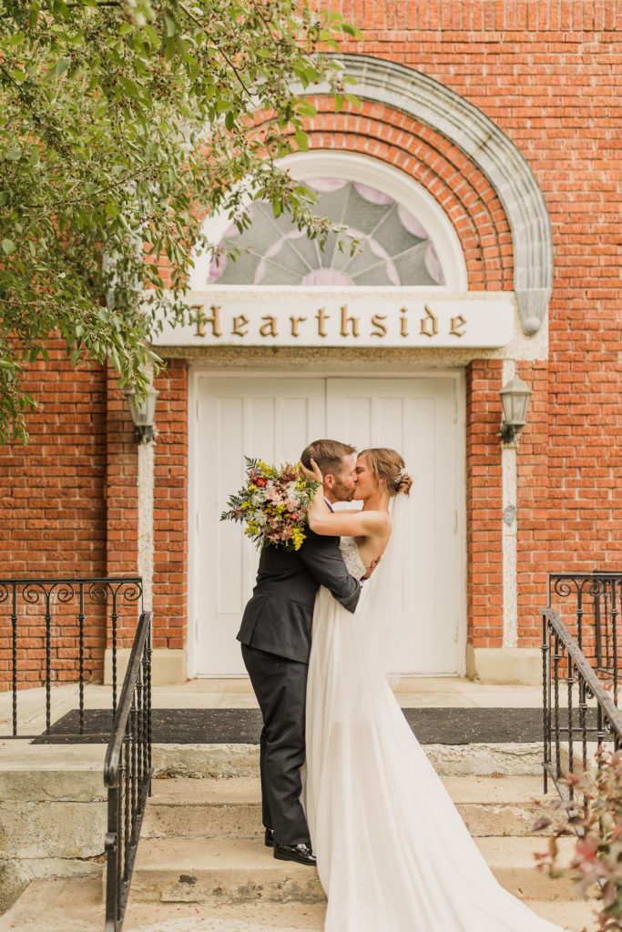 Bride and groom sharing a kiss outside Hearthside Event Center, one of the Top 8 Wedding Venues in Northern Utah