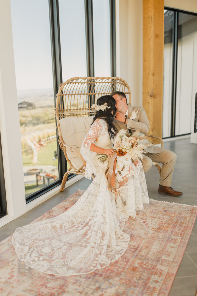 Bride and groom sharing a kiss as they sit on an egg chair at an Airbnb in Bear Lake
