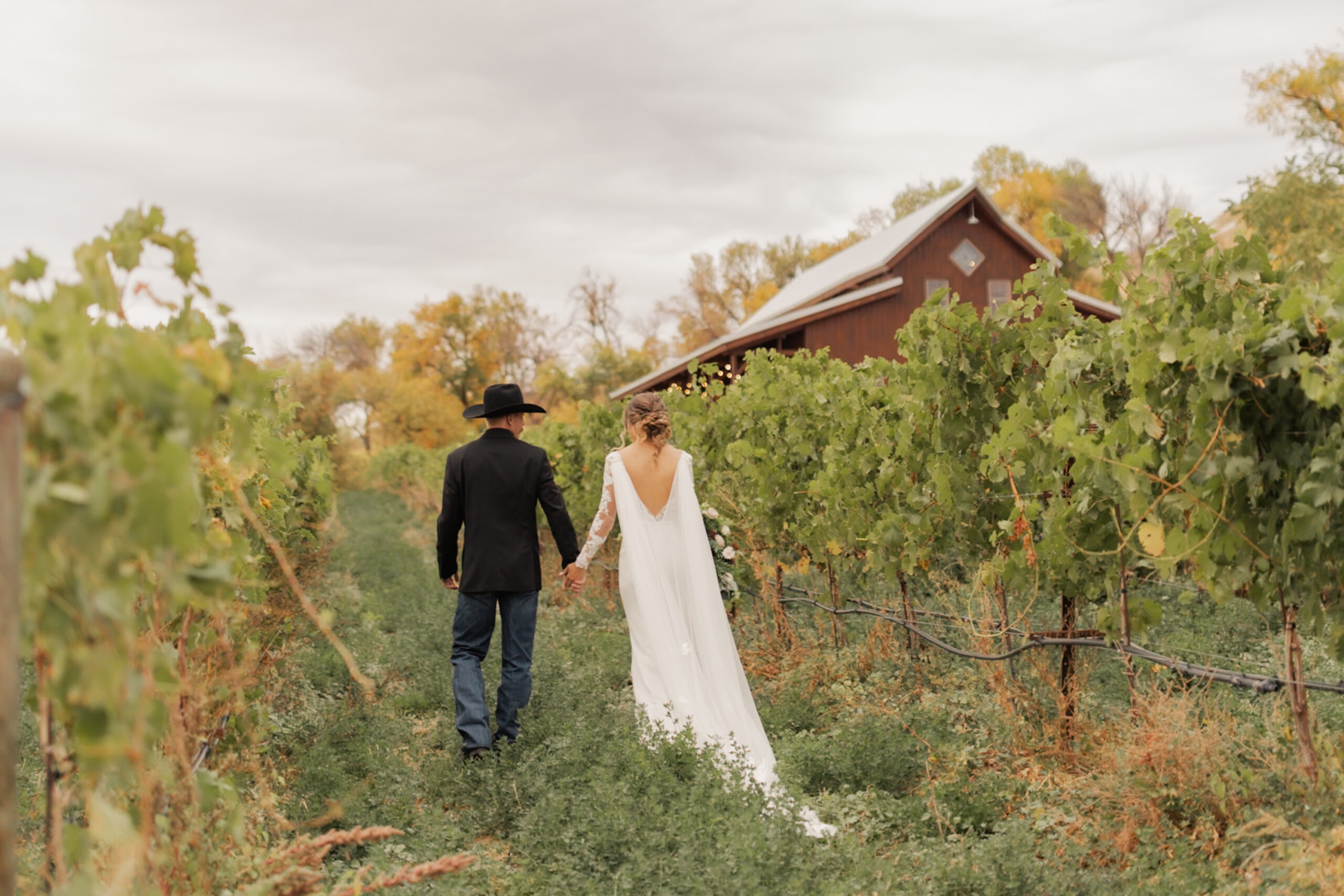 Bride and groom walking holding hands outside Mt. Naomi Vineyards, one of the top 8 wedding venues in Northern Utah