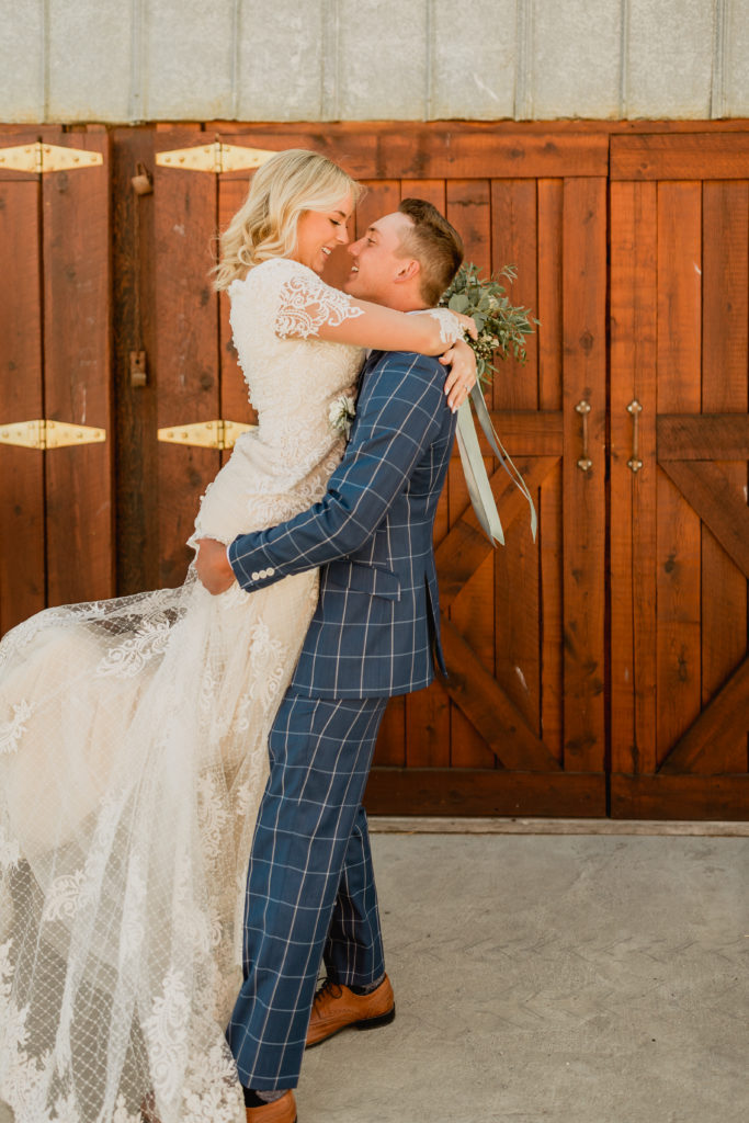 Groom lifts bride up during their wedding shoot at The Smith Barn in Lewiston